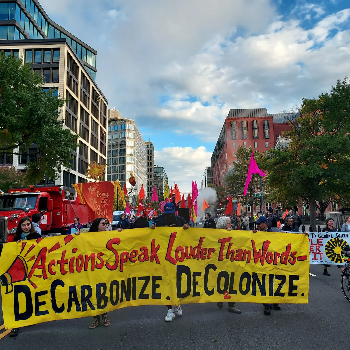 Manifestación popular con pancartas frente a instituciones financieras internacionales
